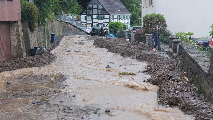 Durch eine Straße läuft braunes Wasser, rechts und und linkd davon liegt Gestein
