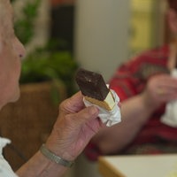 Senioren sitzen an einem Tisch und essen Eis
