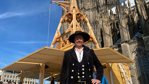 Torsten Klein steht am Dom. Hinter ihm ein Baukran.