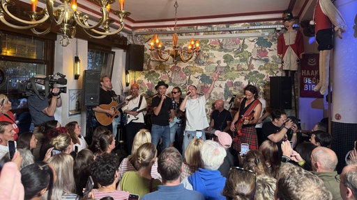 Brings und Cat Ballou singen im Lapidarium auf der Bühne, im Vordergrund Fans.