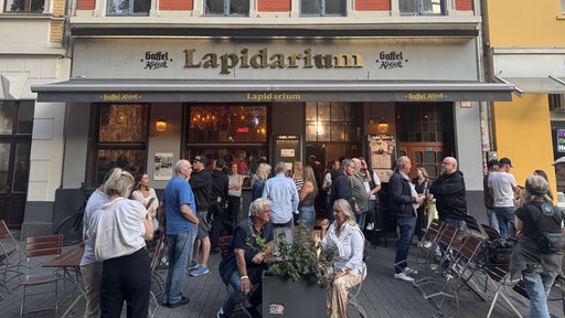 Das Lapidarium in Köln von außen, im Außenbereich stehen Gäste.