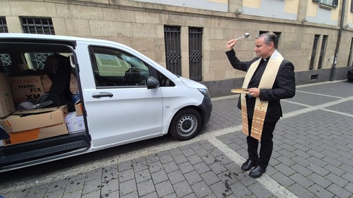 Stadtdechant Markus Hoffmann segnet das Auto.