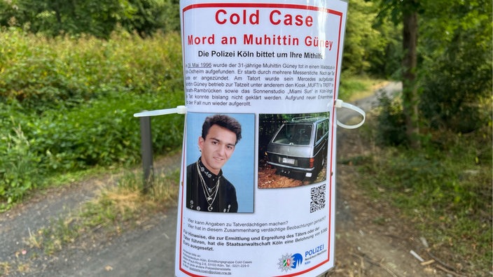Ein Fahndungsplakat zum Tod von Muhittin Güney hängt in einem Kölner Waldstück.
