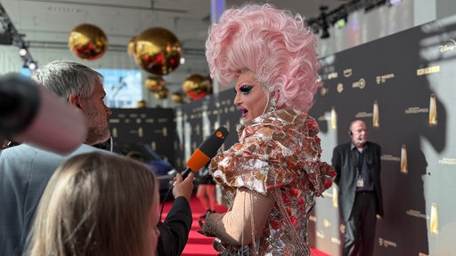 Dragqueen Olivia Jones beim Deutschen Fernsehpreis am Mikrofon des ZDF.