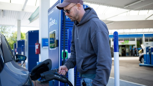 Christian Junge lädt sein E-Auto an einer Ladesäule am Bonner Verteiler.