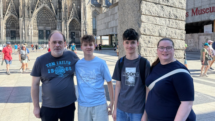 Die vierköpfige Familie Baumann auf dem Weg den Kölner Dom zu besuchen
