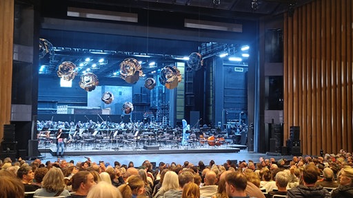 Blick auf die Bühne der Oper Köln mit viel Publikum im Zuschauersaal
