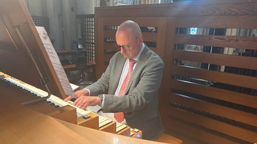 Dom-Organist Wolf-Rüdiger Spieler sitzt an einer Orgel im Kölner Dom.