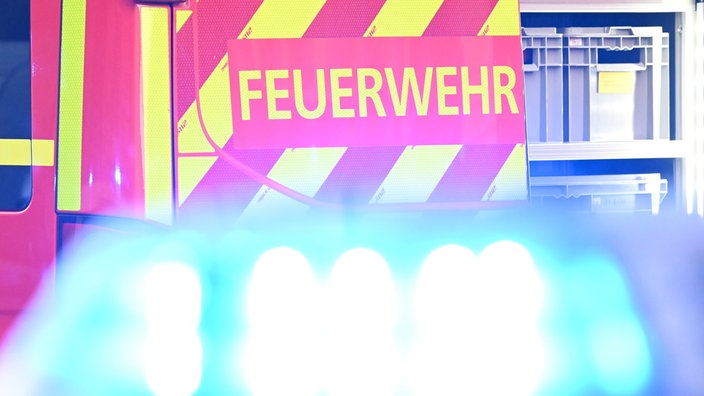 Ein Fahrzeug der Feuerwehr steht bei einem Einsatz auf einer Straße.
