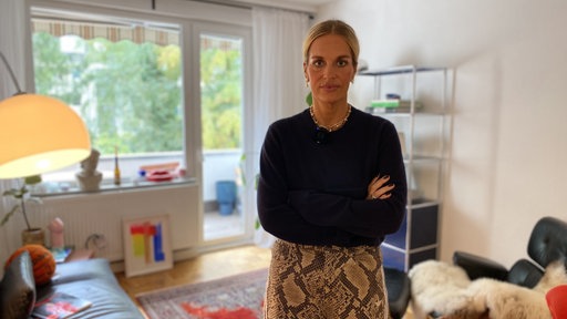 Florine Bruns steht in einem Wohnzimmer