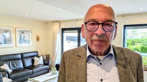 Friedrich Ohst steht in seinem Wohnzimmer.