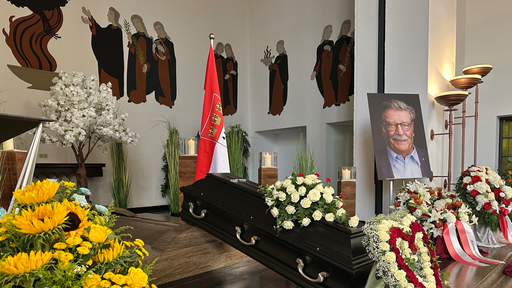 Der Sarg von Fritz Schramma umringt von Blumen, daneben ein Foto Schrammas.