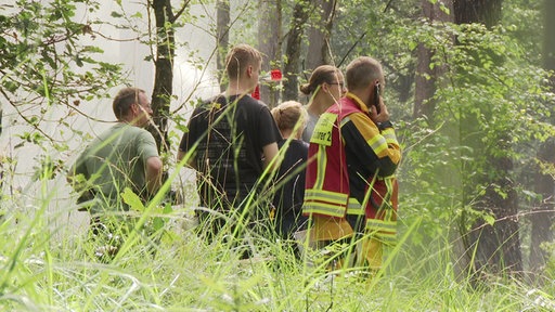 Feuerwehrleute sortieren sich beim Einsatz in der Wahner Heide