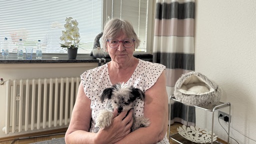 Gudrun Marquardt sitzt mit ihrem Hund in ihrer Wohnung.