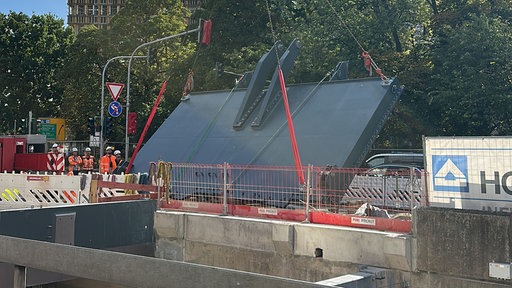 Mehrere Bauarbeiter bauen das neue Hochwasserschutztor ein.