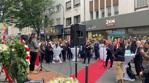 Derya Karadag spricht auf einer Bühne in der Keupstraße.