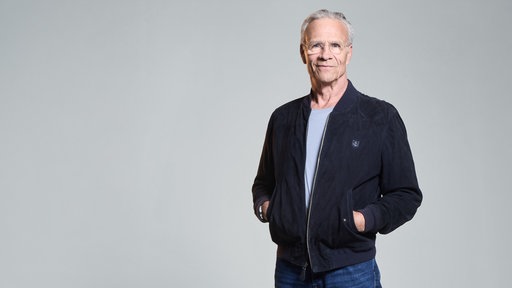 Schauspieler Klaus Johannes Behrendt vor einer weißen Wand