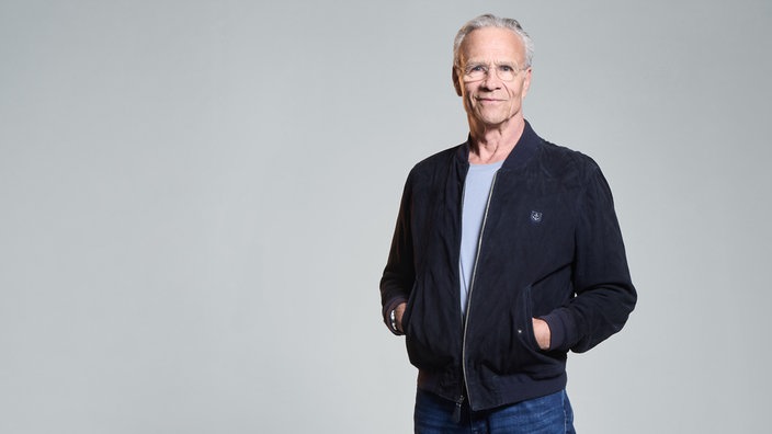 Schauspieler Klaus Johannes Behrendt vor einer weißen Wand