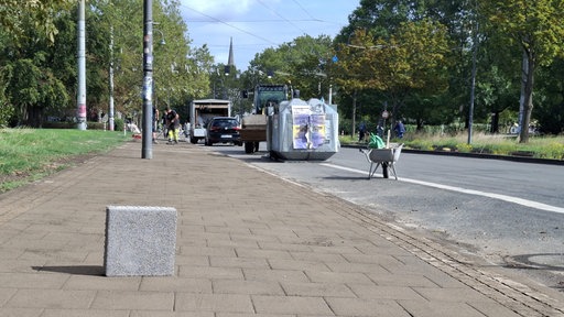 Ein Klimastein steht auf einem Bürgersteig in Köln
