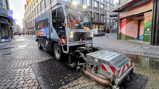 Auf dem Bild ist ein AWB-Reinigungswagen zu erkennen. Er fährt durch die Straße