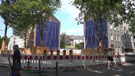 Auf dem Bild ist eine weitläufige Absperrung zu erkennen, dahinter ein einsturzgefährdetes Haus.