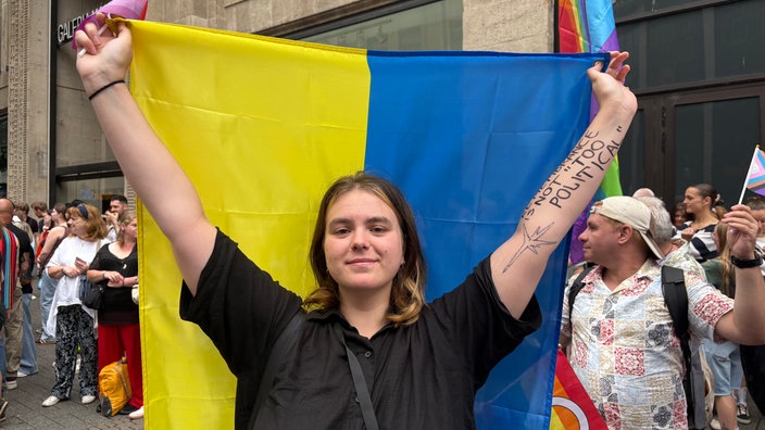Liliia Stetsiuk aus Kiew hält eine große ukrainische Flagge hoch.
