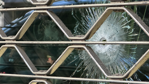 In einem Fensterglas an der Vorderfront des Geschäfts ist deutlich das Einschussloch