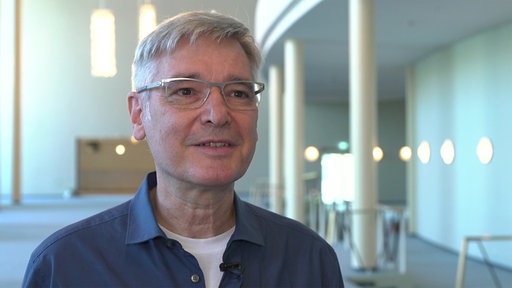  Mann mit kurzen grauen Haaren und Brille