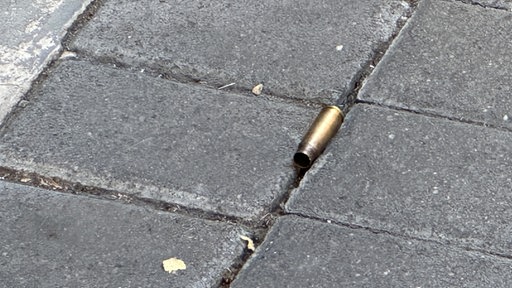 Eine Patronenhülse liegt auf dem Pflaster