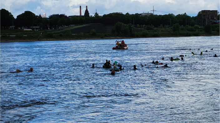 Schwimmer und Rettungsboot im Rhein. 