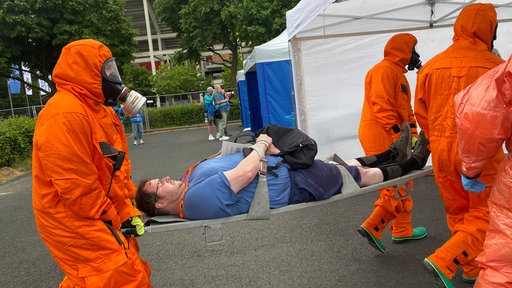 Ein Mann wird auf einer Trage von Einsatzkräften trasnportiert