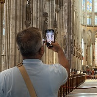 Ein Besucher des Kölner Doms fotografiert mit dem Handy.