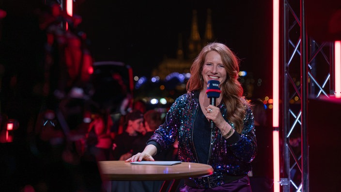 WDR Moderatorin Janine Breuer-Kolo steht am Live-Set 