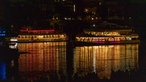 Beleuchtete Schiffe liegen im dunkeln auf dem Rhein.