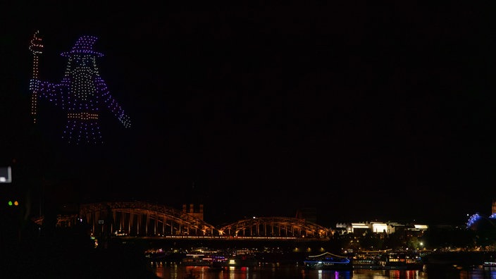 Drohnen bilden die Formation eines Zauberers am dunklen Himmel.