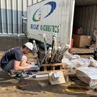 zwei Männer bauen Feuerwerke zusammen. Im Hintergrund ein Container
