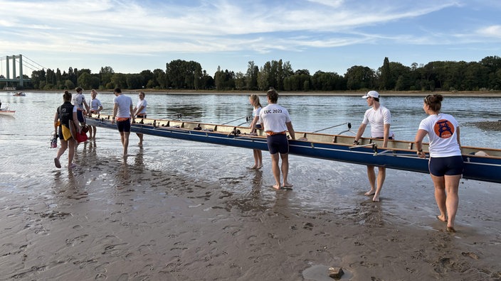 Ruderer setzen ihr Boot in den Rhein.