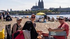 Drei Frauen picknicken am Rheinufer