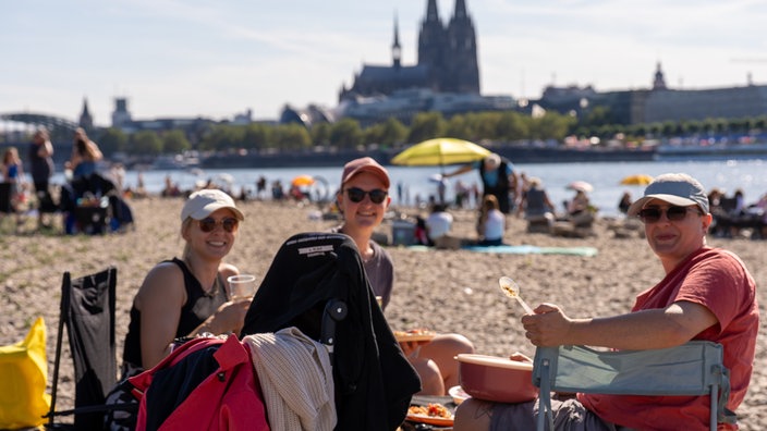 Drei Frauen picknicken am Rheinufer