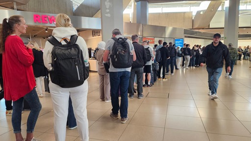 Menschen warten in einer langen Schlange