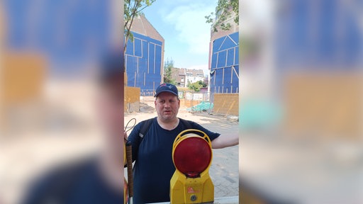 Ein Mann steht hinter einem Baustellenlicht