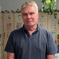 Markus Weber steht in seinem Büro vor alten Fahndungsplakaten