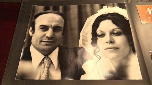 Mohamed und Erika Zarini blicken für ihr Hochzeitsfoto in die Kamera.