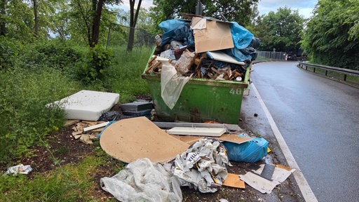 Ein überfüllter Müllcontainer steht in Köln-Dünnwald.