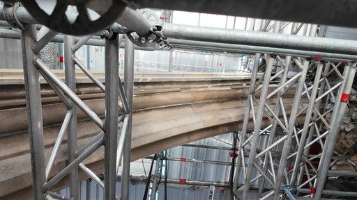 Ein Steinbogen am Kölner Dom und ein Gerüst