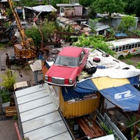 Drohnenaufnahme von Odonien, ein rotes Auto steht auf einem Hausdach