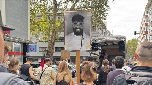Menschen demonstrieren mit einem Bild Pedro Coronas durch die Kölner Innenstadt.