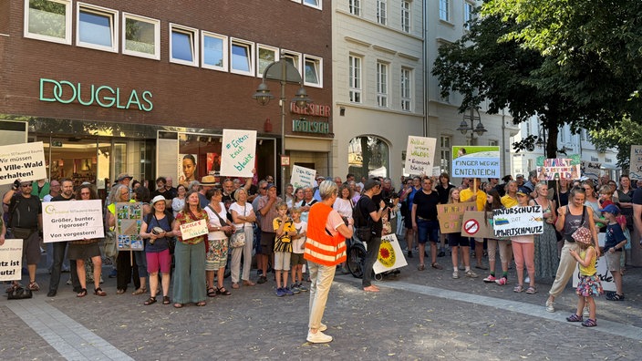 Menschen mit Plakaten demonstrieren gegen die Erweiterung des Phantasialands in Köln.