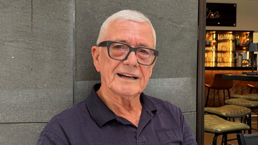 Rainer Diederichs sitzt in einem Kölner Café und schaut in die Kamera.