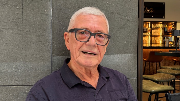 Rainer Diederichs sitzt in einem Kölner Café und schaut in die Kamera.